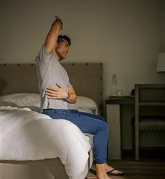 Man stretching in bed