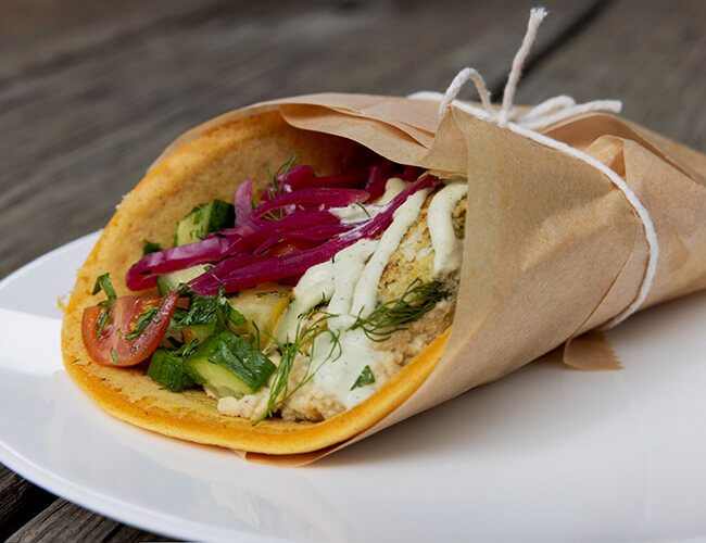 Gyro with pickled red onions, cucumbers, tomatoes, and a creamy sauce