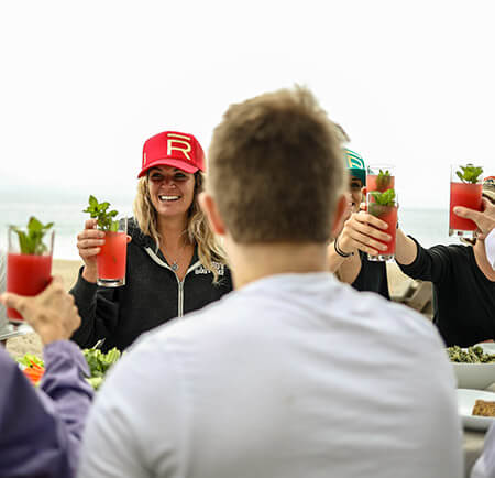 Group dining on the beach with bloody mary's