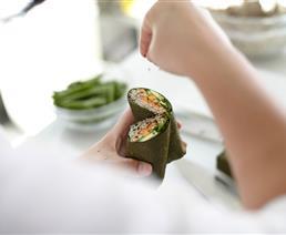 A chef prepares a wrap