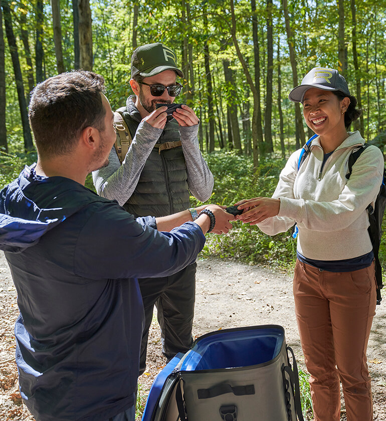 A group of hikers in the woods eating snacks