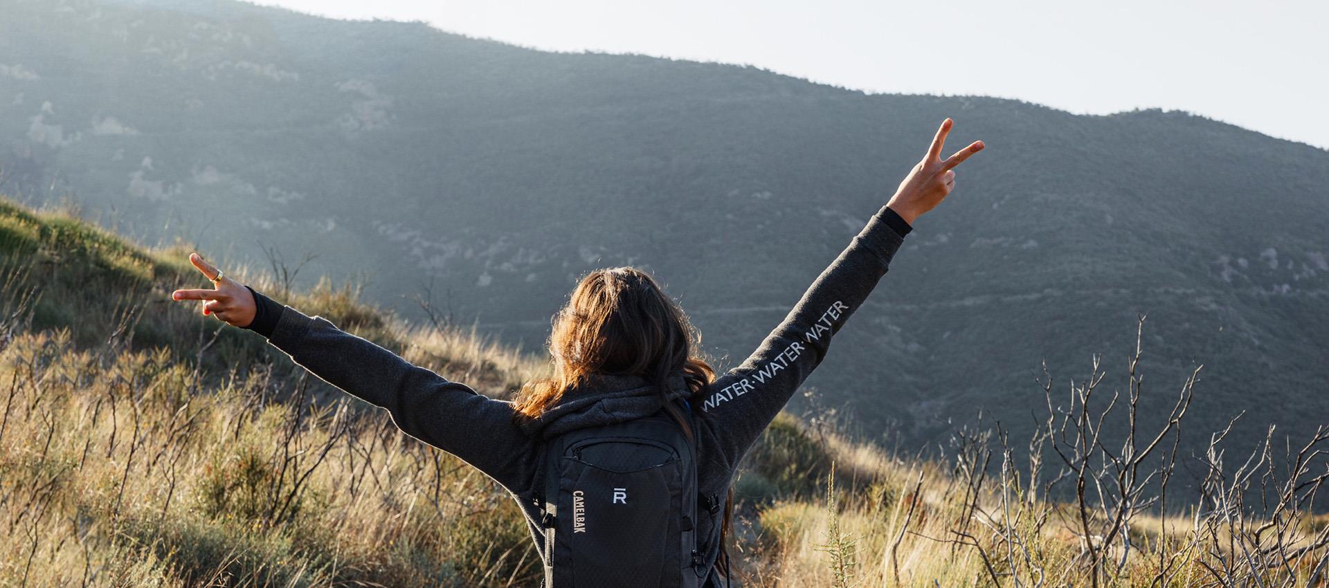 Woman with arms up on trail