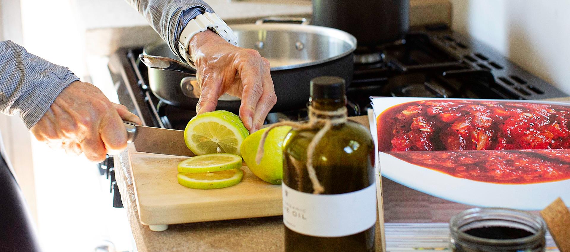 Someone cutting up a lime on a cutting board