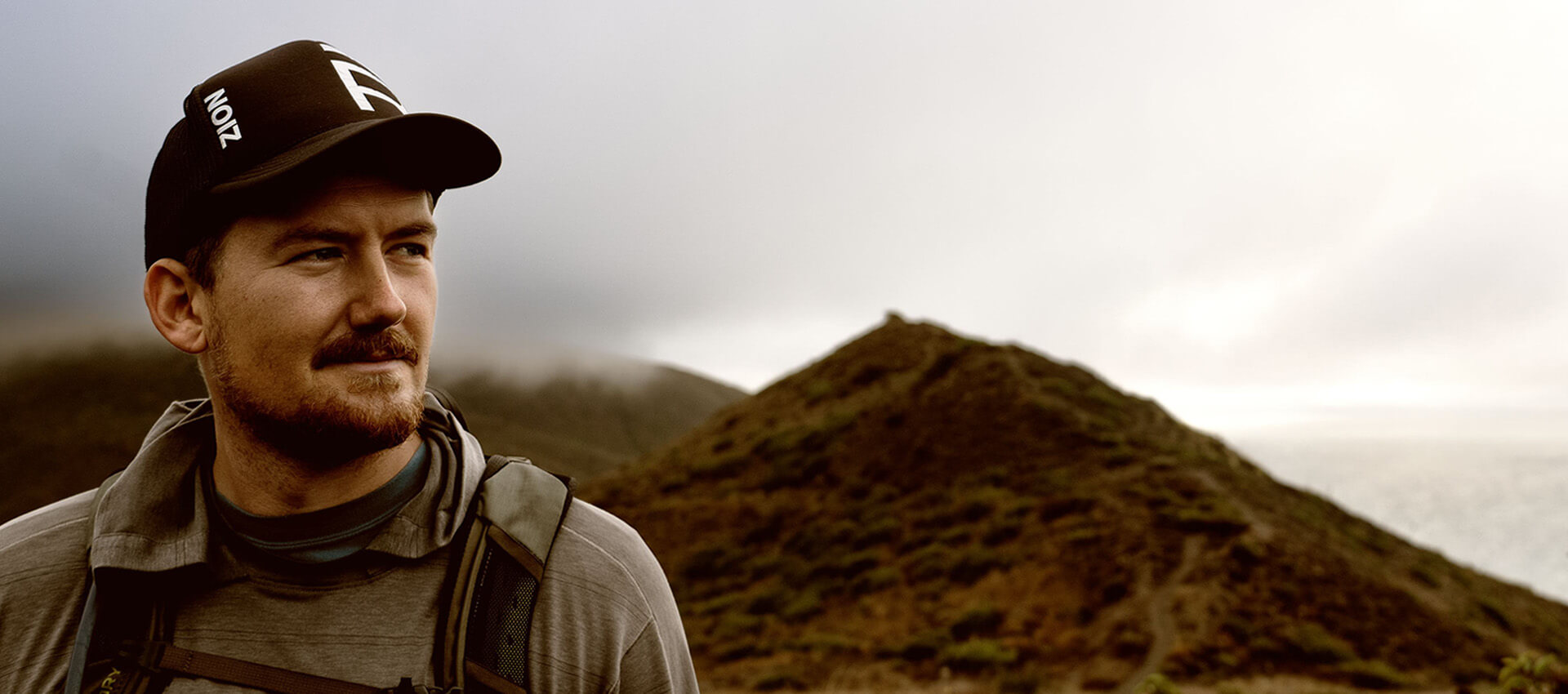 A male hiker looks on