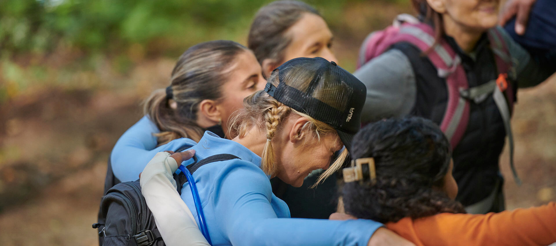 Group huddle of hikers with their heads down